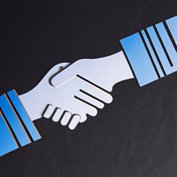 A paper cutout of a handshake indicating negotiation