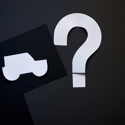 A paper cutout car with a paper cutout question mark