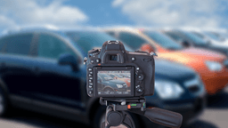 A camera taking an image of a car dealership's car lot, outside